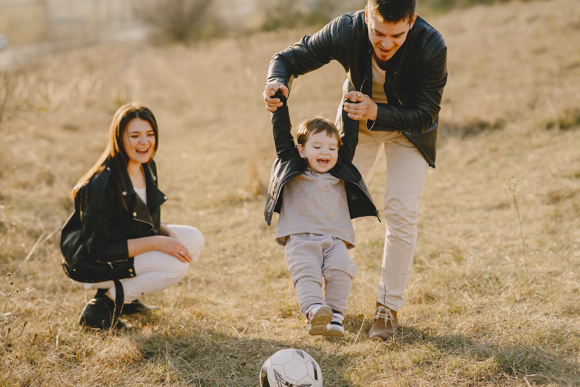 mom-and-dad-helping-her-child-play-football-family-goals