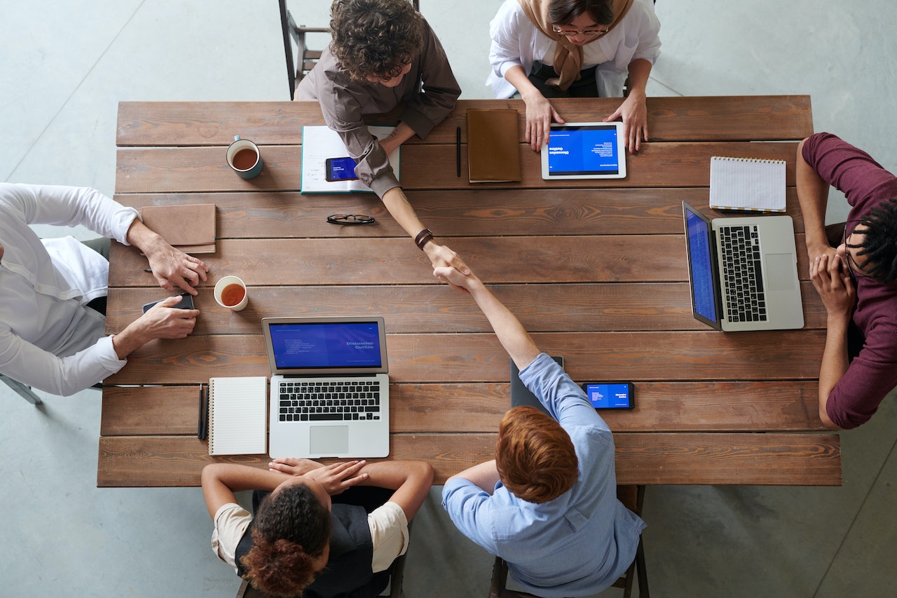 people in table working and shaking hands