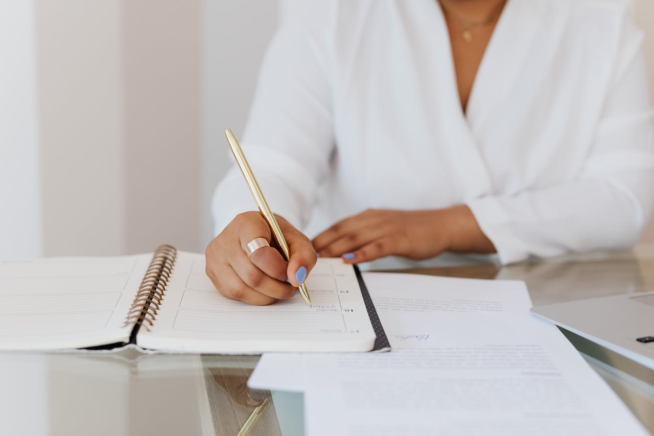 person-in-white-top-writing-on-notebook