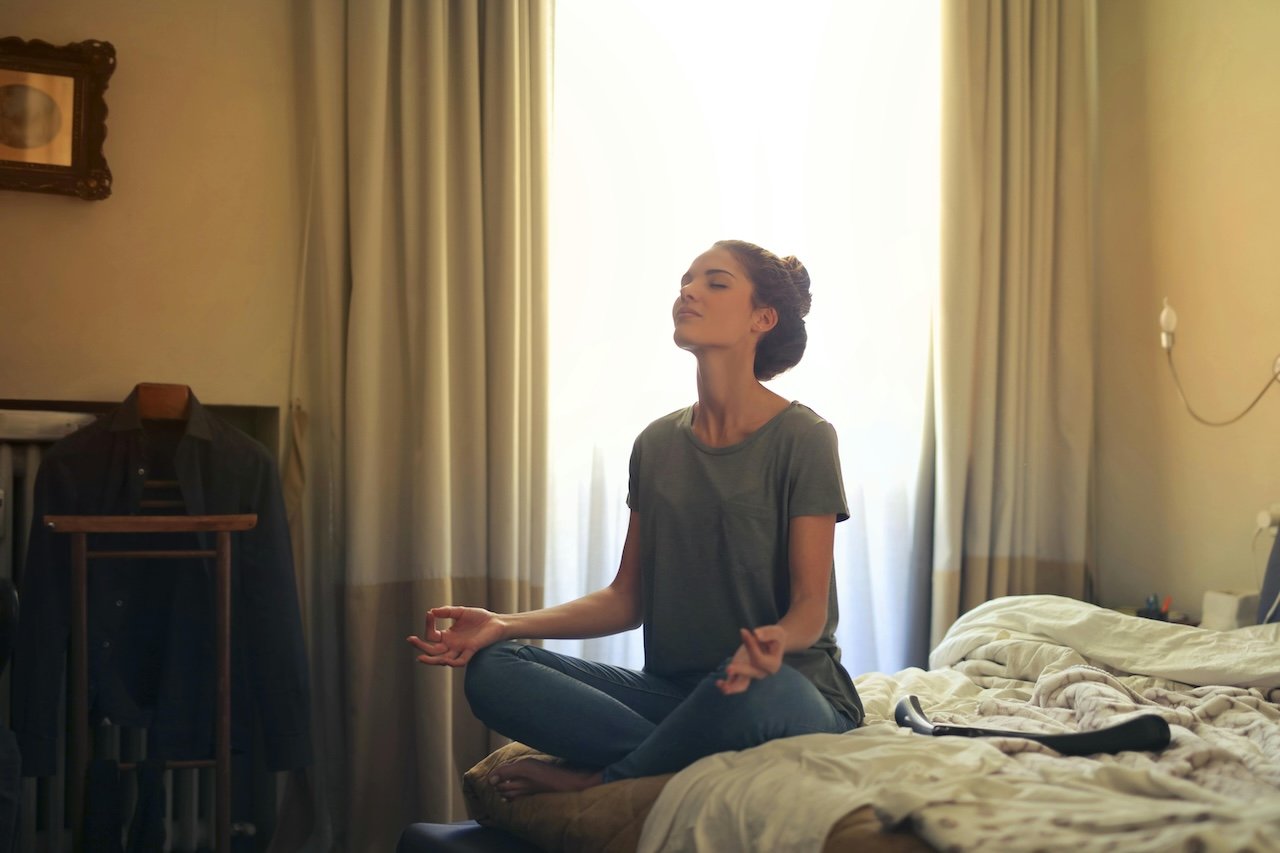 woman-meditating-on-her-bed-make-it-part-of-your-routine