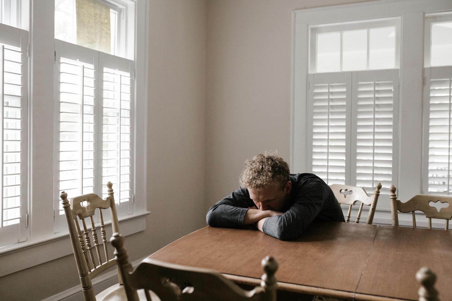 man-sits-at-table-catastrophizing