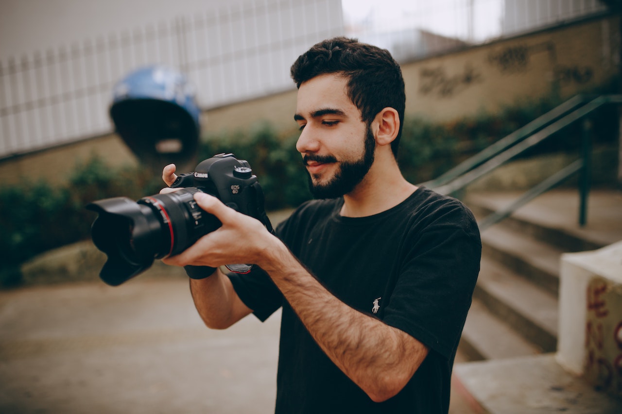 photographer-looking-at-his-camera-while-shooting-outdoors-best-work-life-balance-jobs