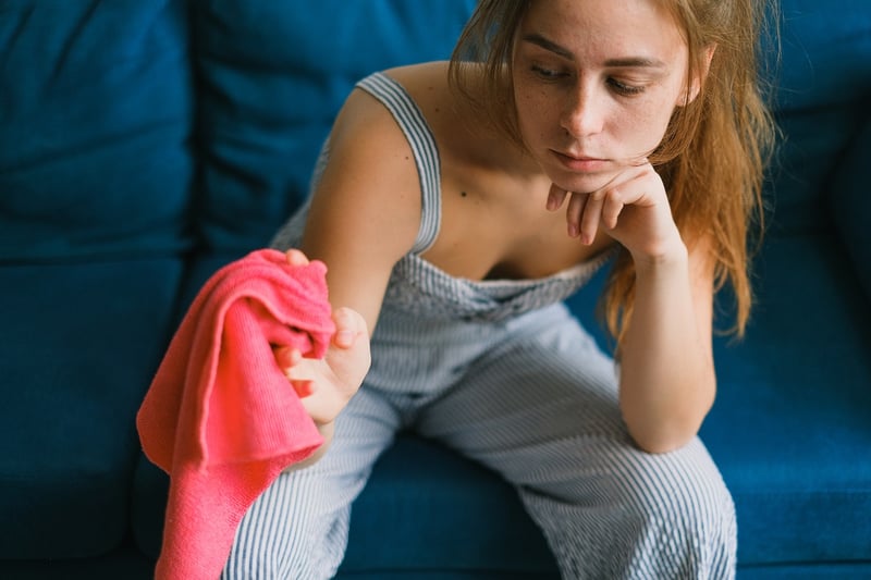 sad-woman-sitting-in-couch-looking-at-cloth-what-to-do-when-you-are-sad