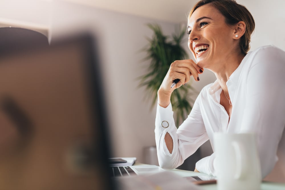 smiling-woman-sitting-in-her-desk-at-office-what-is-brain-fog