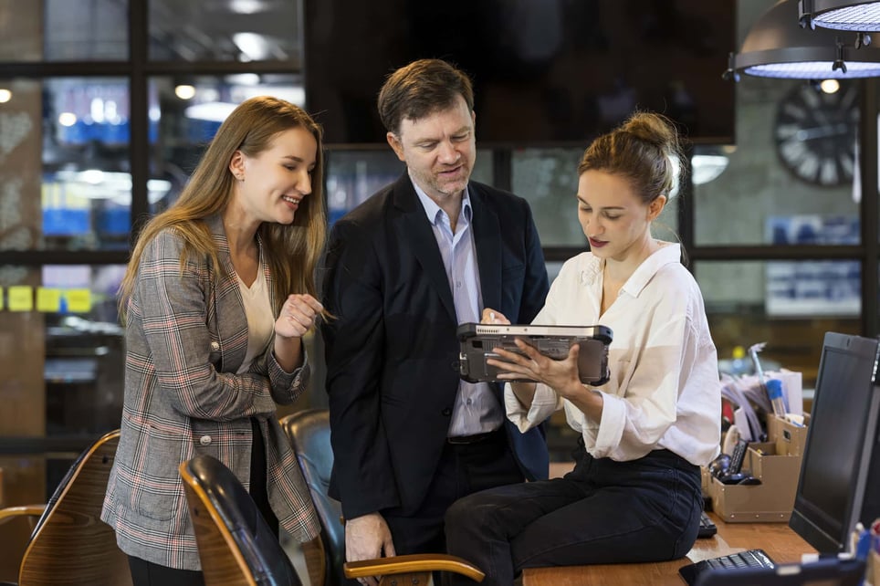 three-coworkers-looking-at-a-tablet-in-board-room-full-time-vs-part-time-benefits (1)