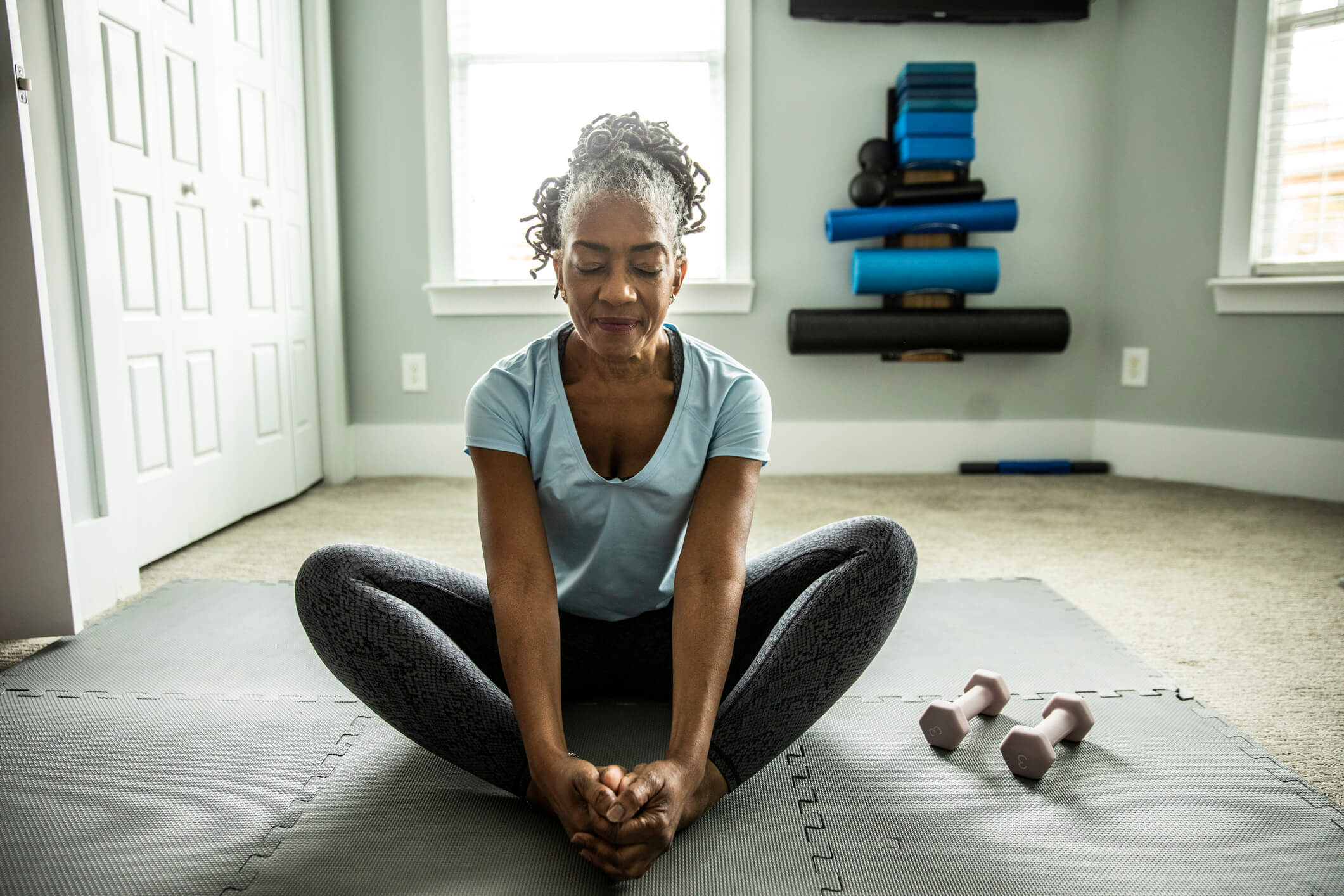 woman exercising on her mat at home to achieve office wellness