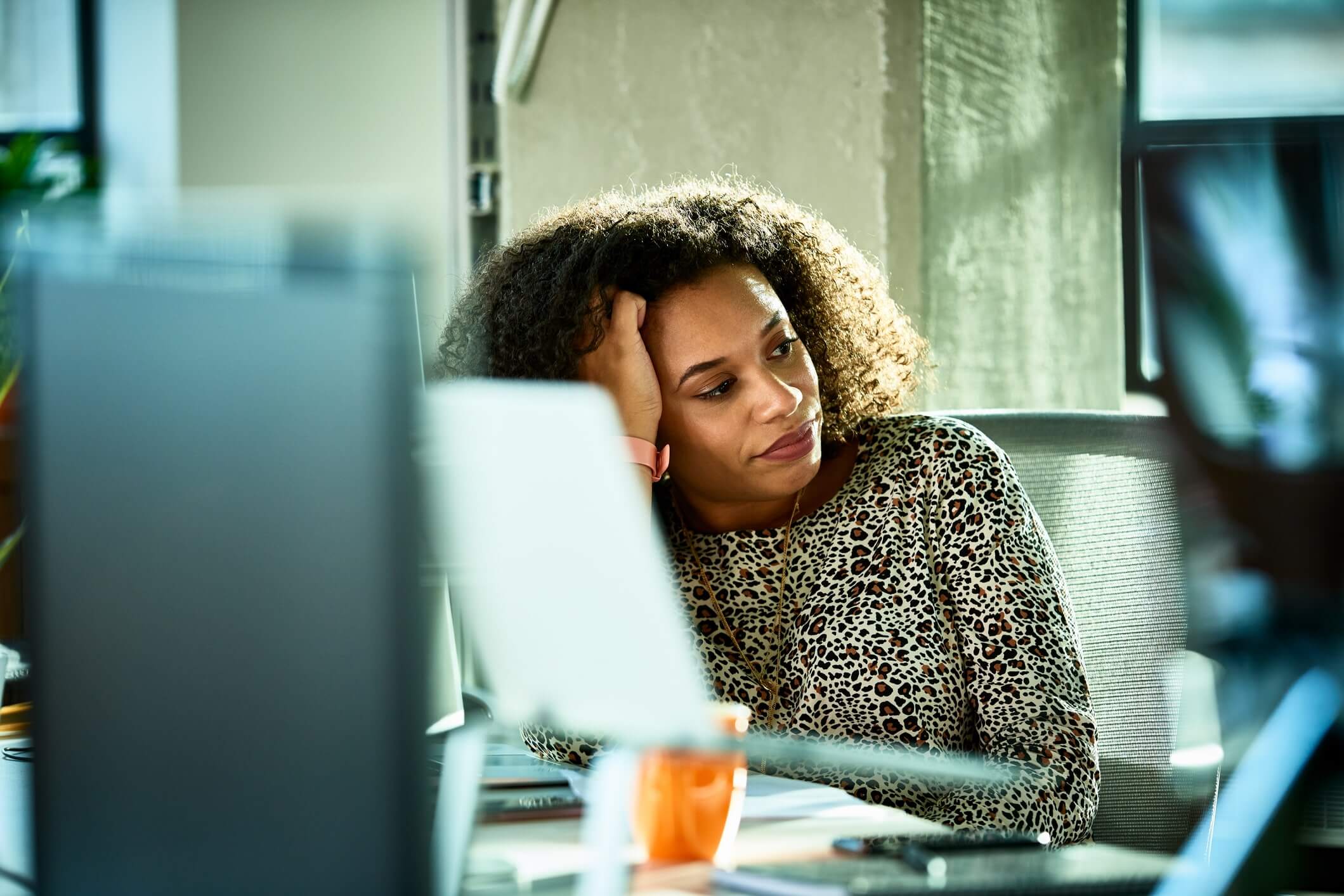 woman sitting in front of computer screen looking bored