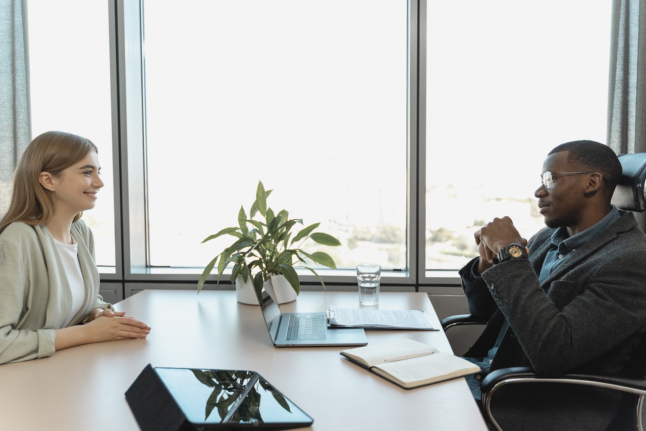 woman-being-interviewed-at-mans-office-in-business-attire-unique-interview-questions-to-ask-employer