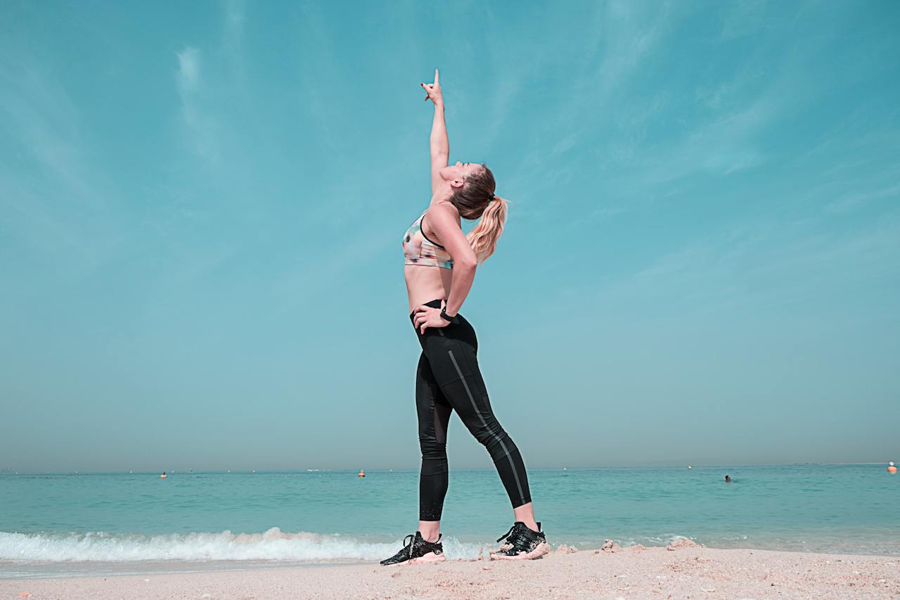 woman-pointing-at-sky-on-seashore