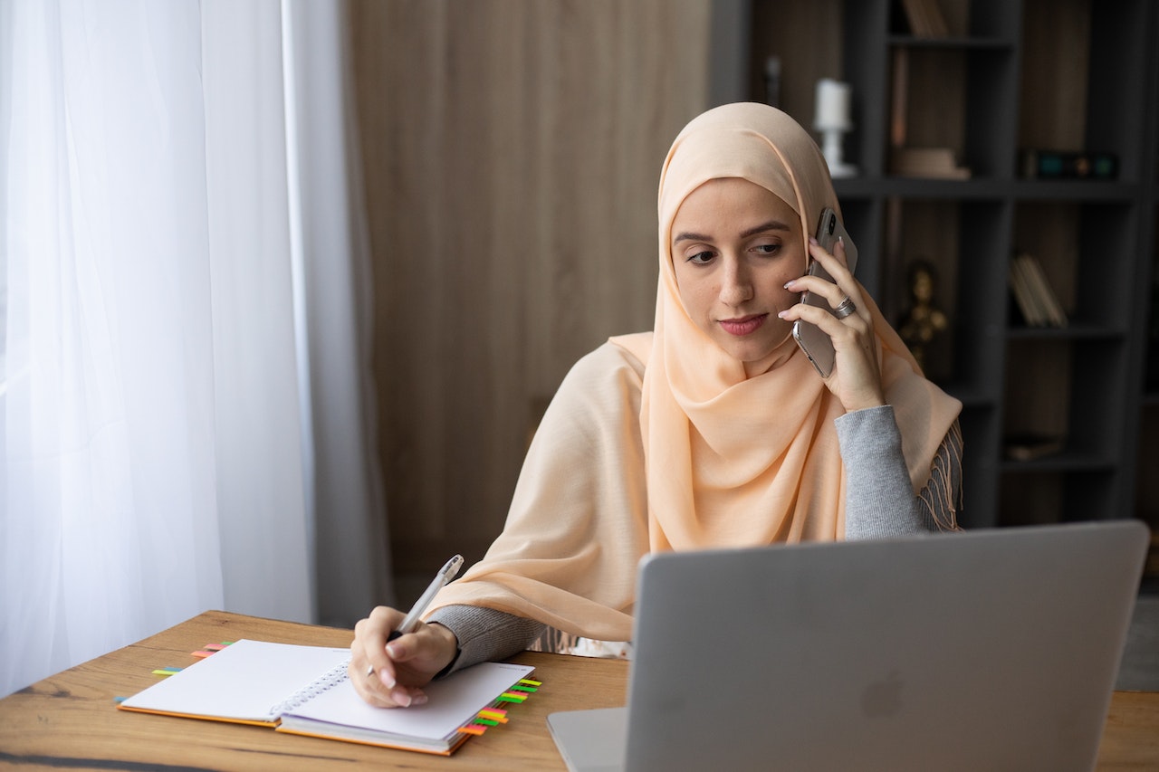 woman-using-his-phone-while-writing-on-notebook-process-mapping