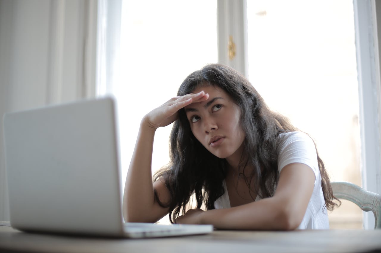 young-annoyed-female-freelancer-using-laptop-at-home