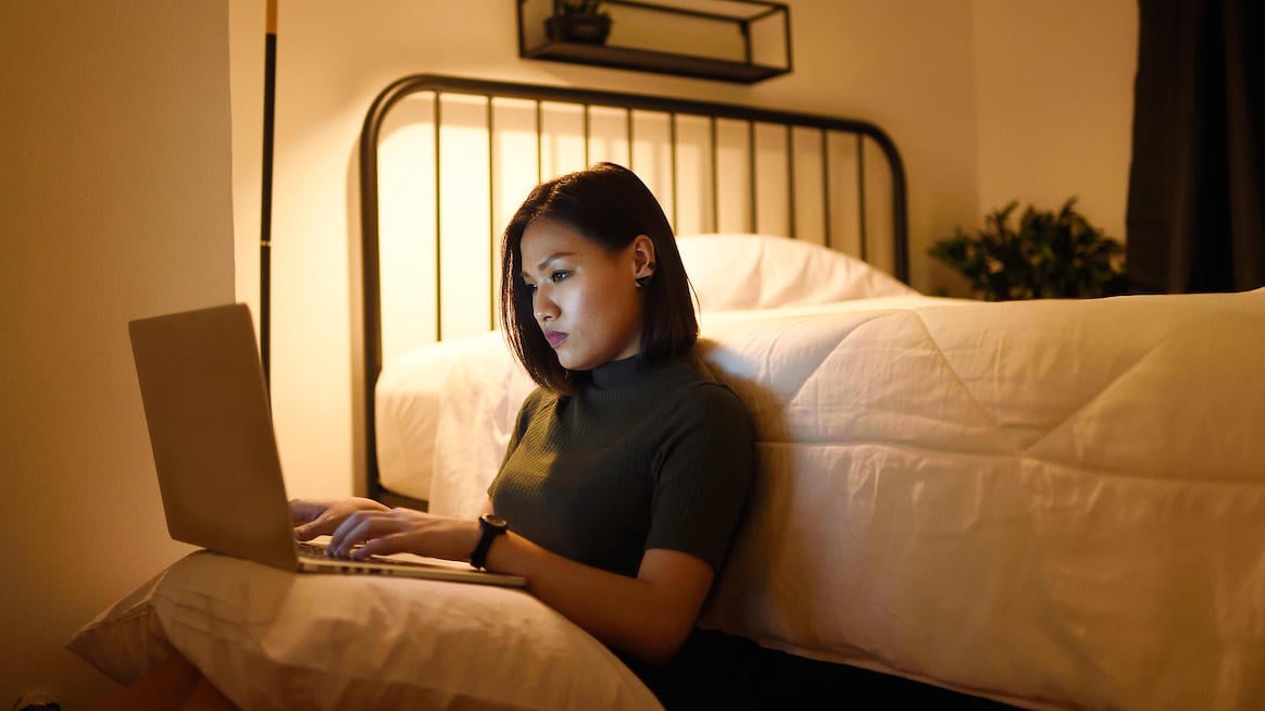 hustle-culture-woman-working-late-on-laptop-next-to-bed