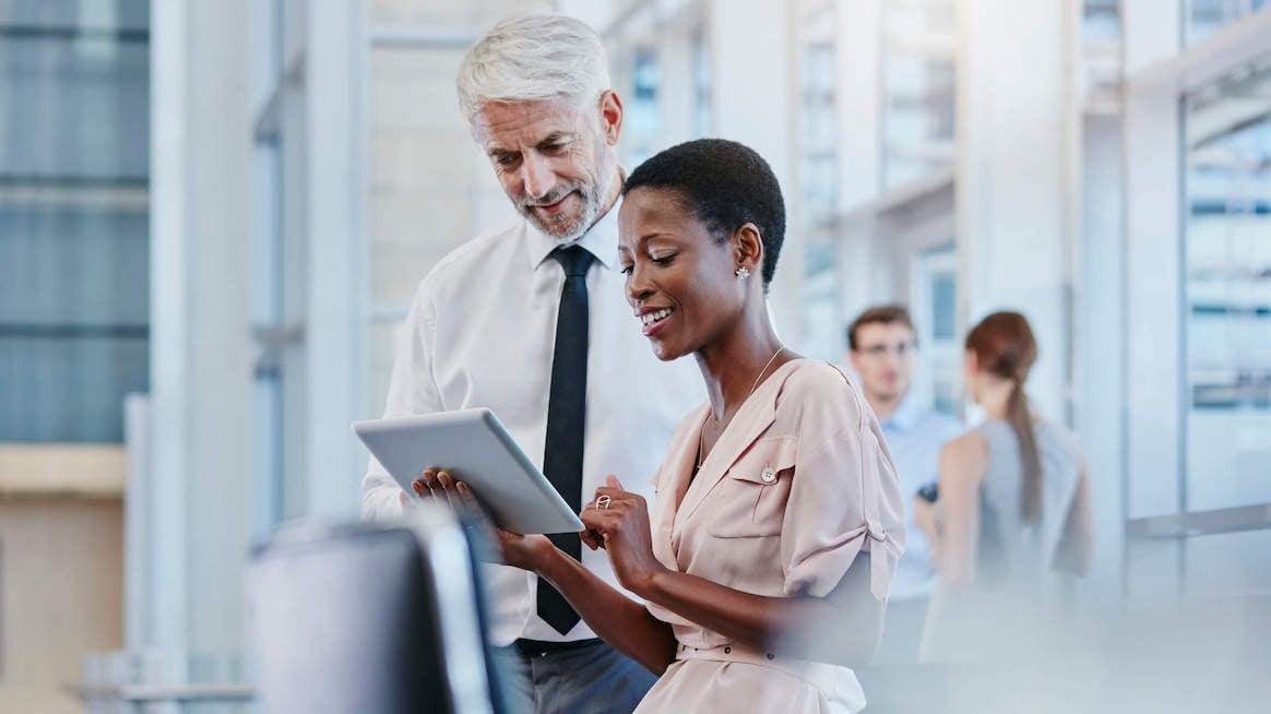 knowledge-management-woman-looking-up-info-next-to-colleague