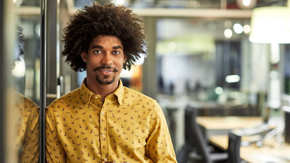 professionalism-in-the-workplace-man-smiling-in-conference-room