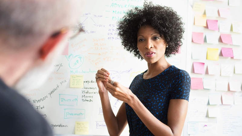 systems-thinking-woman-at-whiteboard-strategizing