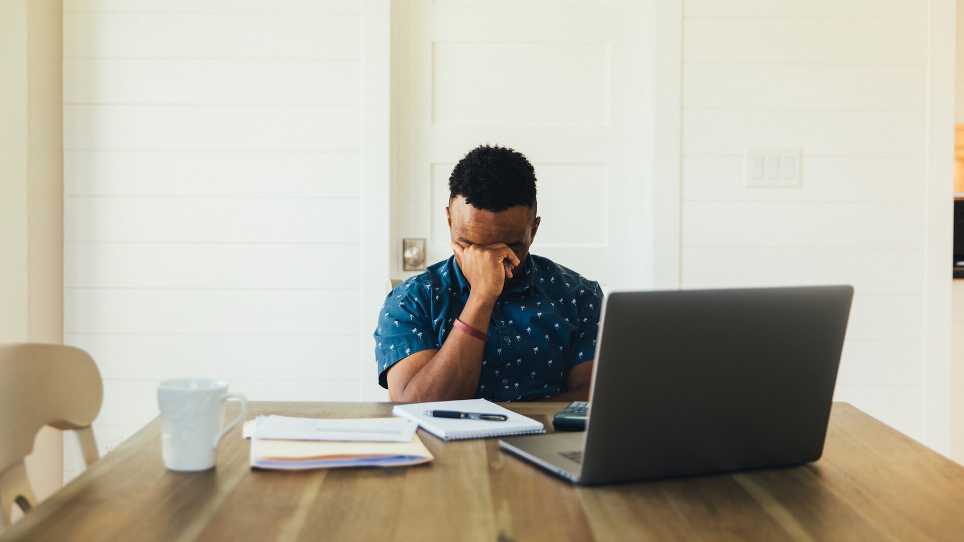 debt-and-mental-health-person-paying-bills-frustrated-at-computer