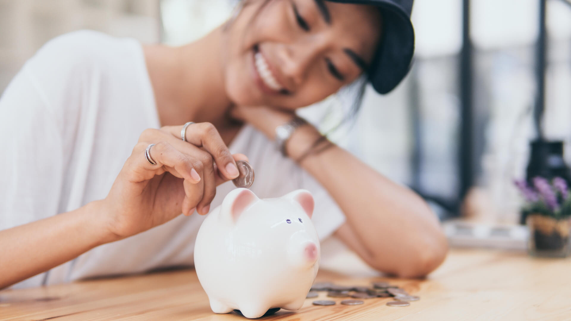 financial-security-person-putting-money-in-piggy-bank
