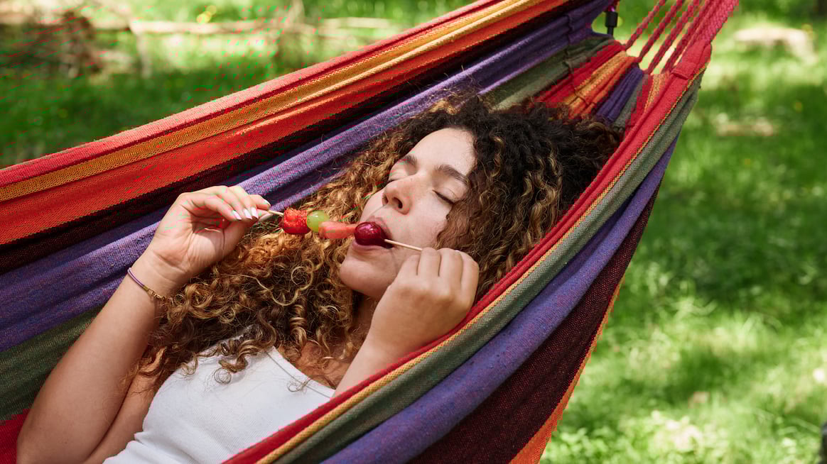 woman in hammock eating fruit - mindful eating