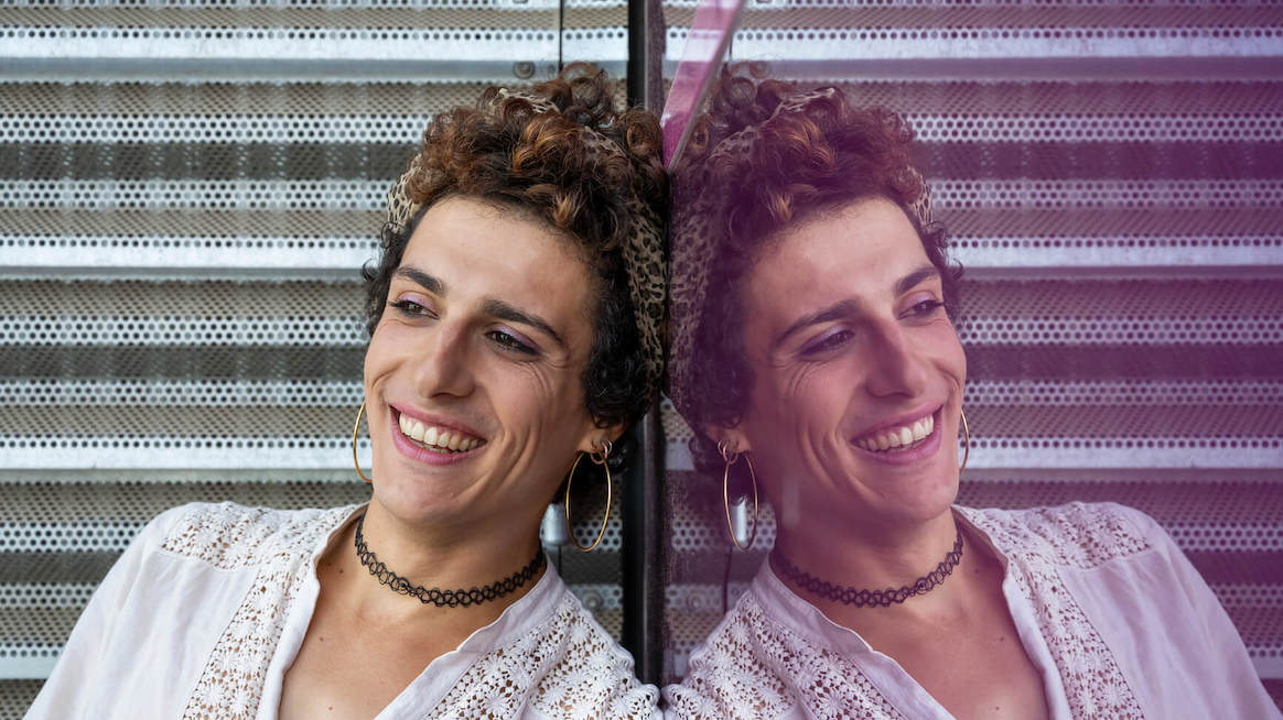 whats-the-deal-with-gender-pronouns-person-leaning-against-mirror