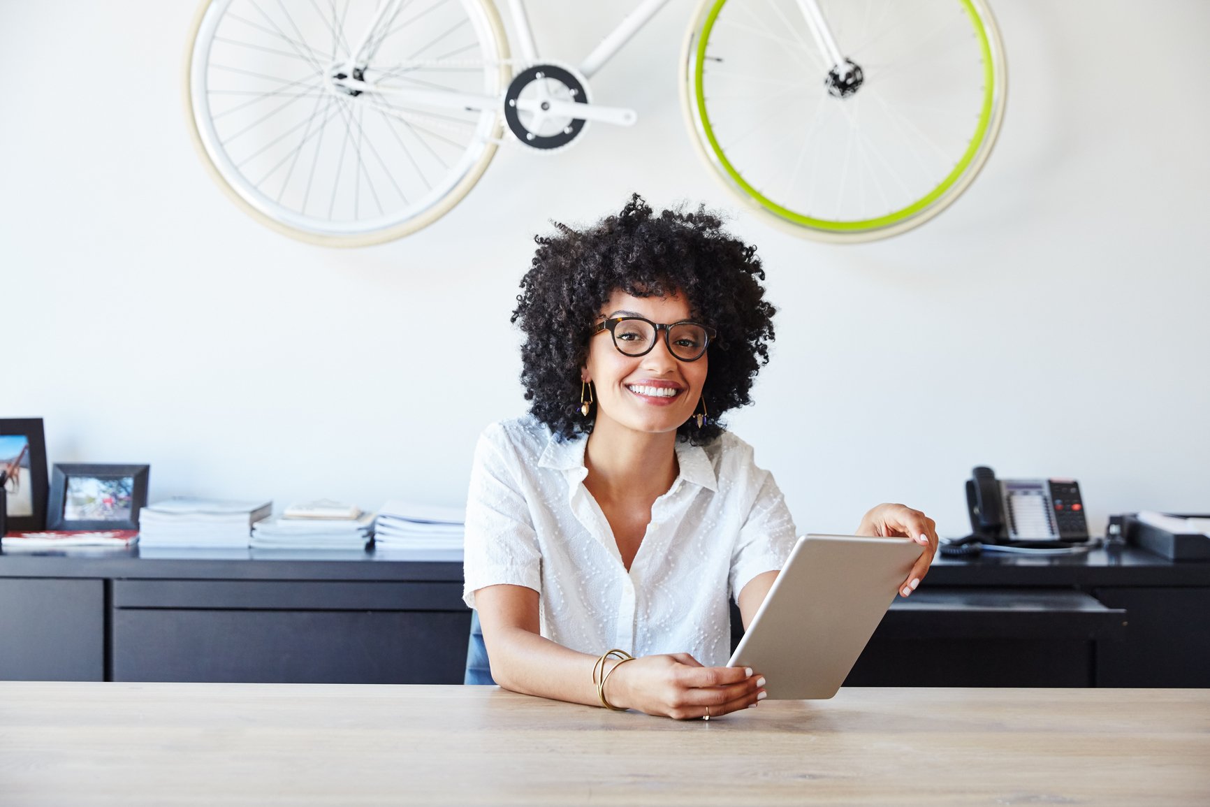 woman-sits-at-desk-smiling-entrepreneur-tips